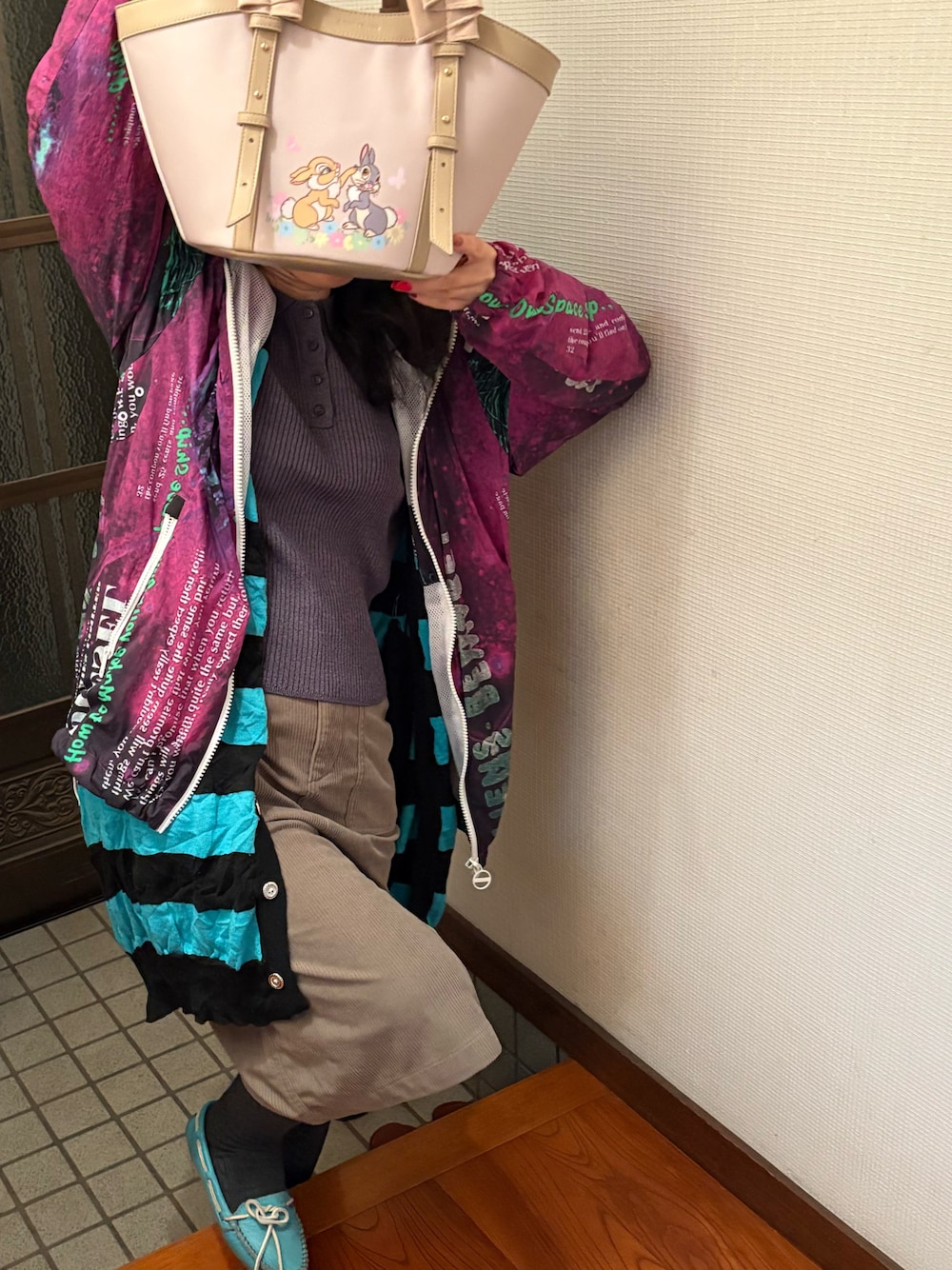 グレー系のニット/セーター、ブルー系のモカシン/デッキシューズ、ベージュ系のハンドバッグを着用したレディースの秋コーディネートの1枚目の写真