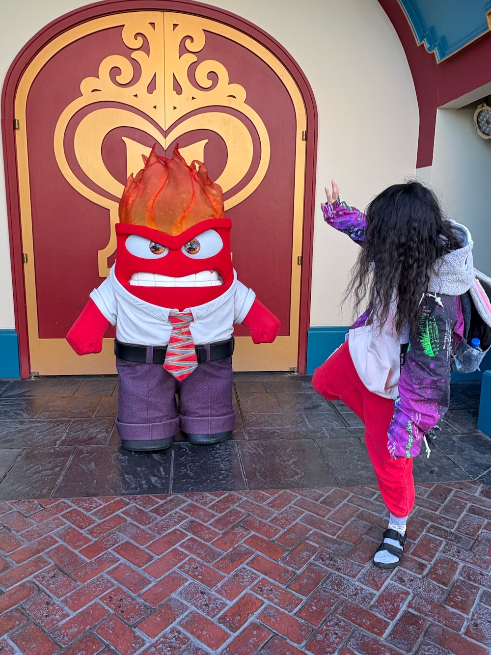 ブラック系のナイロンジャケット、ブラック系のサンダル、レッド系のパンツを着用したレディースの冬コーディネートの1枚目の写真