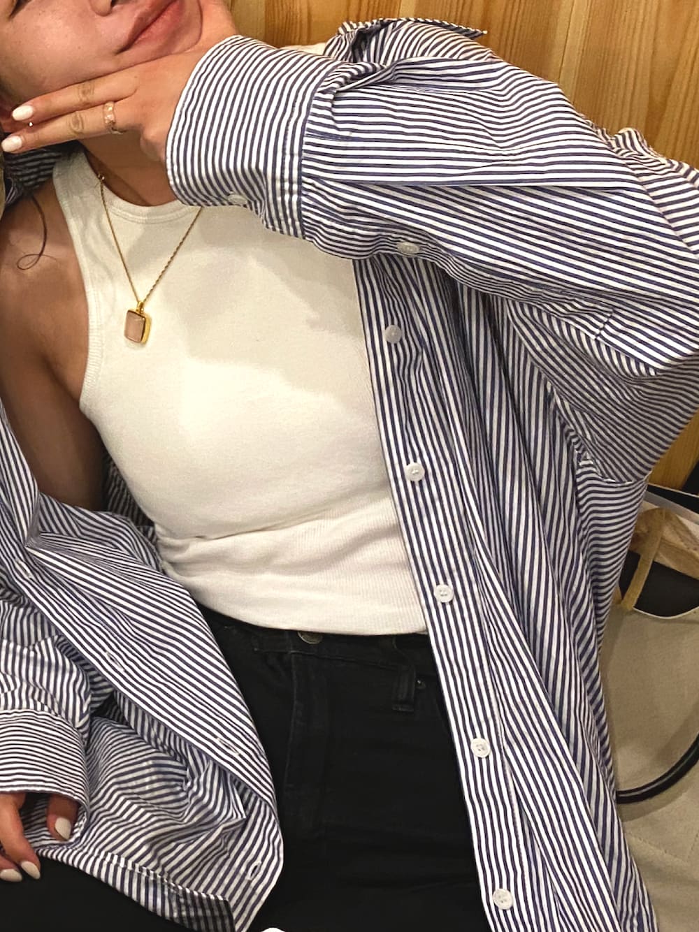 ブルー系のシャツ/ブラウス、ホワイト系のタンクトップ、ブラック系のデニムパンツを着用したレディースの春コーディネートの1枚目の写真