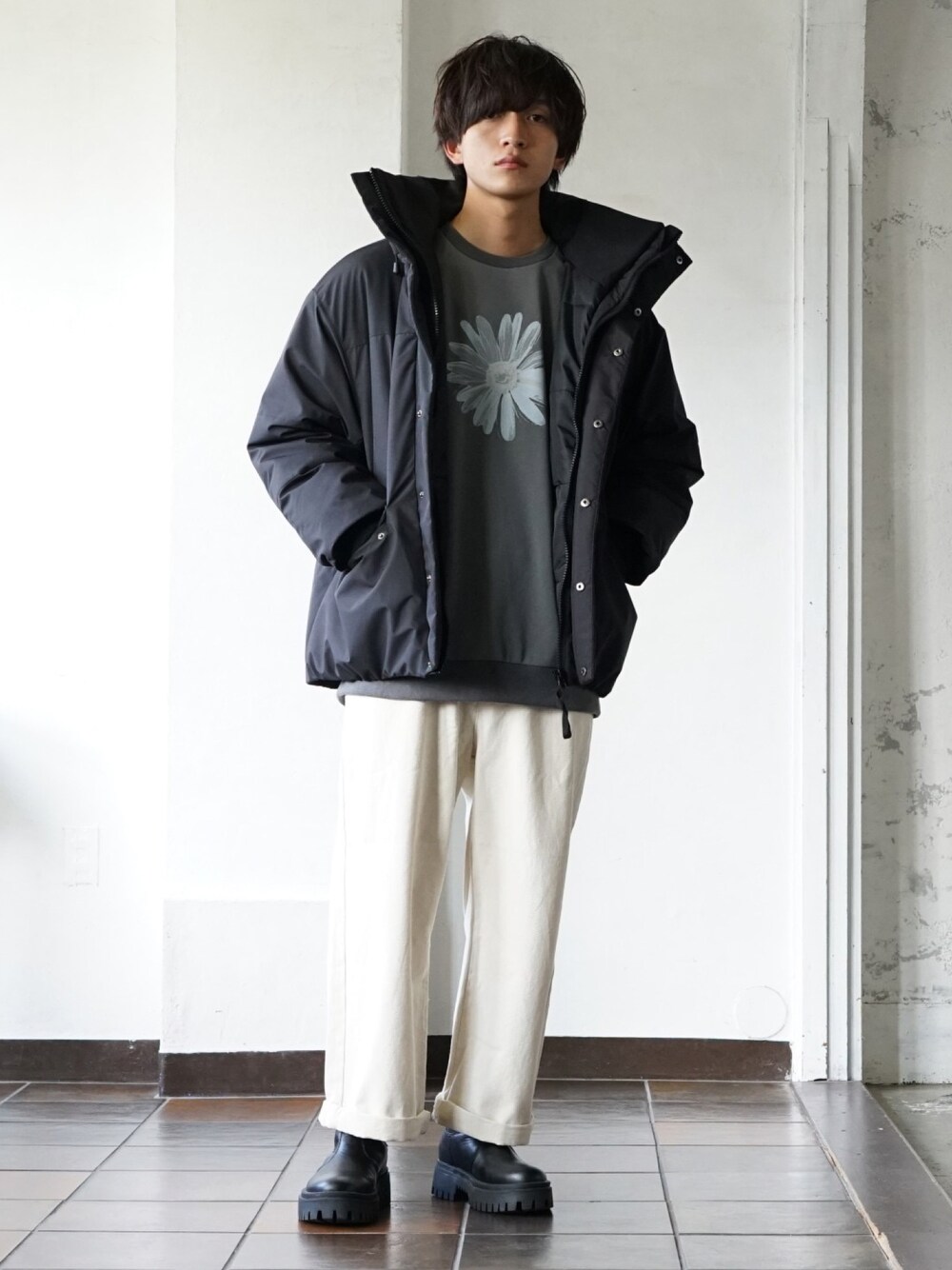 グレー系のスウェット、ブラック系のダウンジャケット/コート、ブラック系のブーツを着用したメンズの冬コーディネートの1枚目の写真