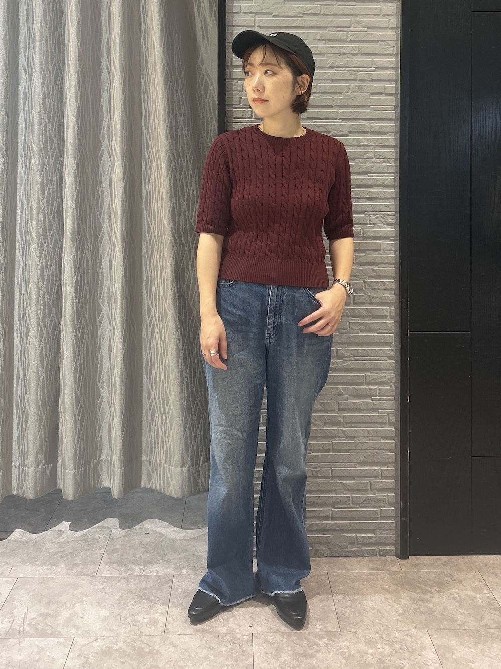 レッド系のニット/セーター、ブルー系のデニムパンツ、ブラック系のパンプスを着用したレディースの秋コーディネートの1枚目の写真