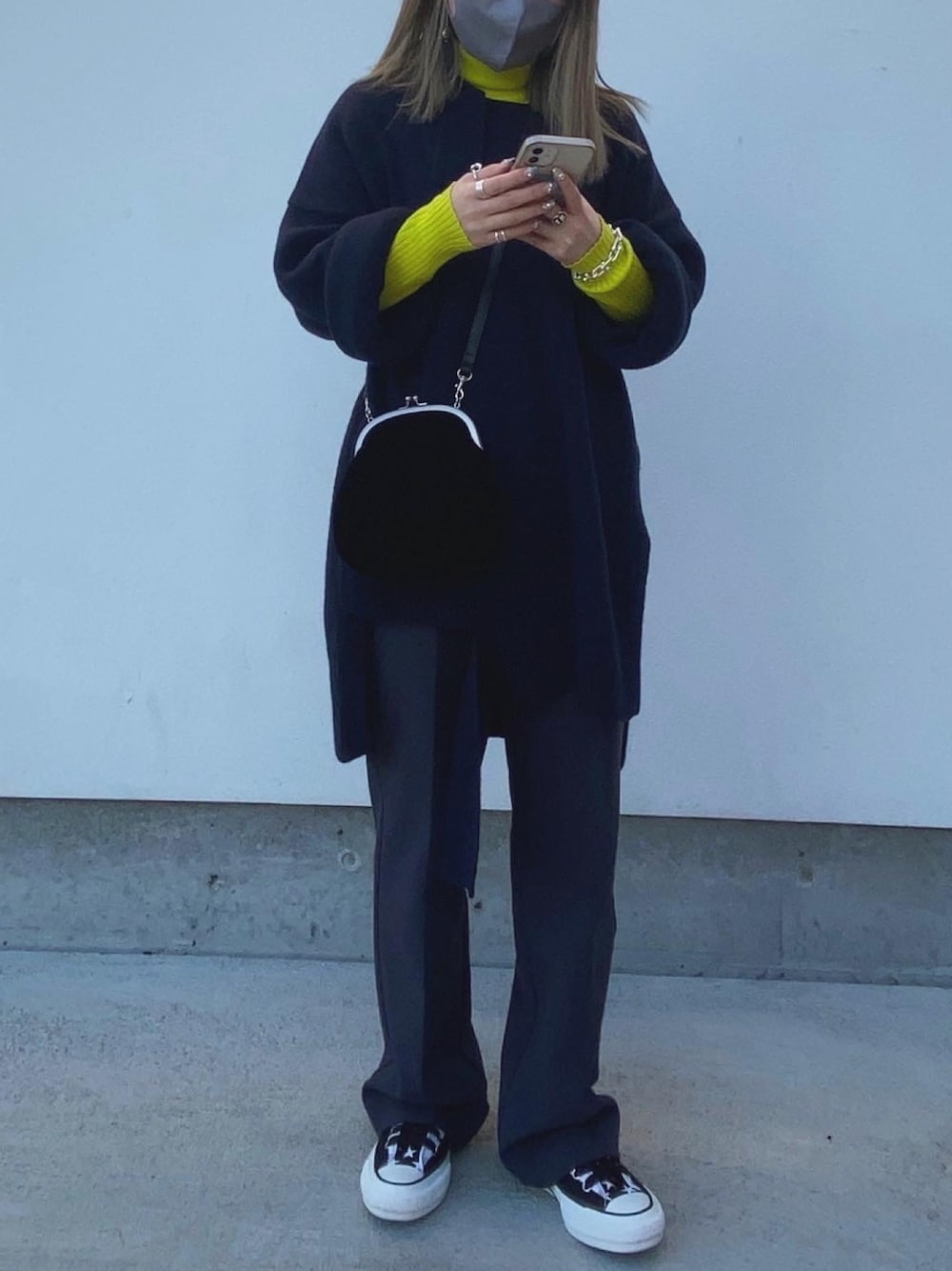 ブルー系のニット/セーター、グレー系のスラックス、ブラック系のスニーカーを着用したレディースの冬コーディネートの1枚目の写真