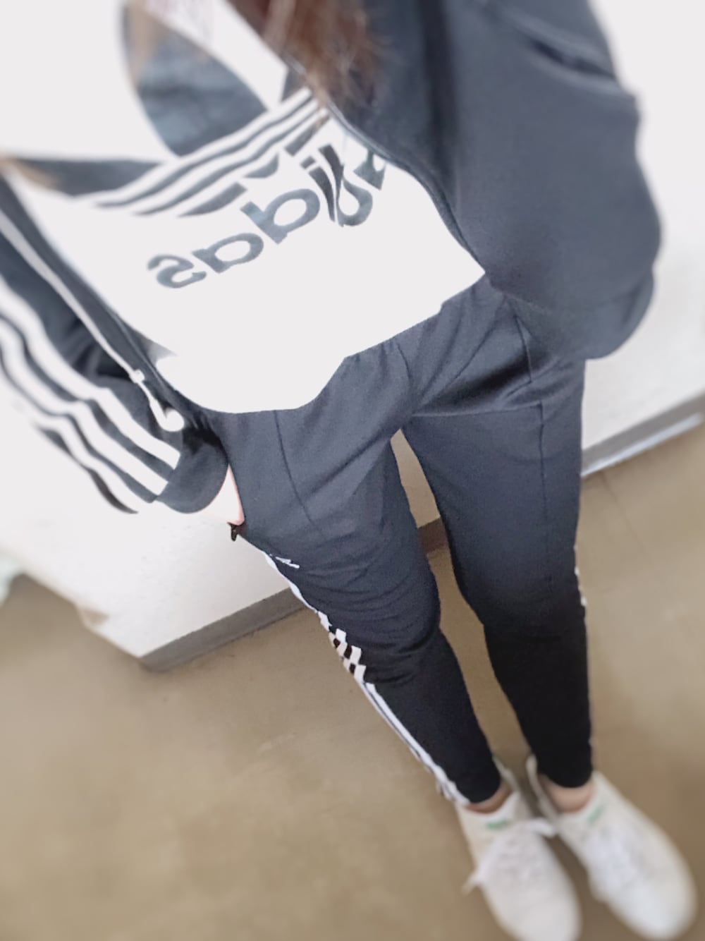 ブラック系のブルゾン、ホワイト系のTシャツ/カットソー、ブラック系のスウェットパンツを着用したレディースの冬コーディネートの1枚目の写真