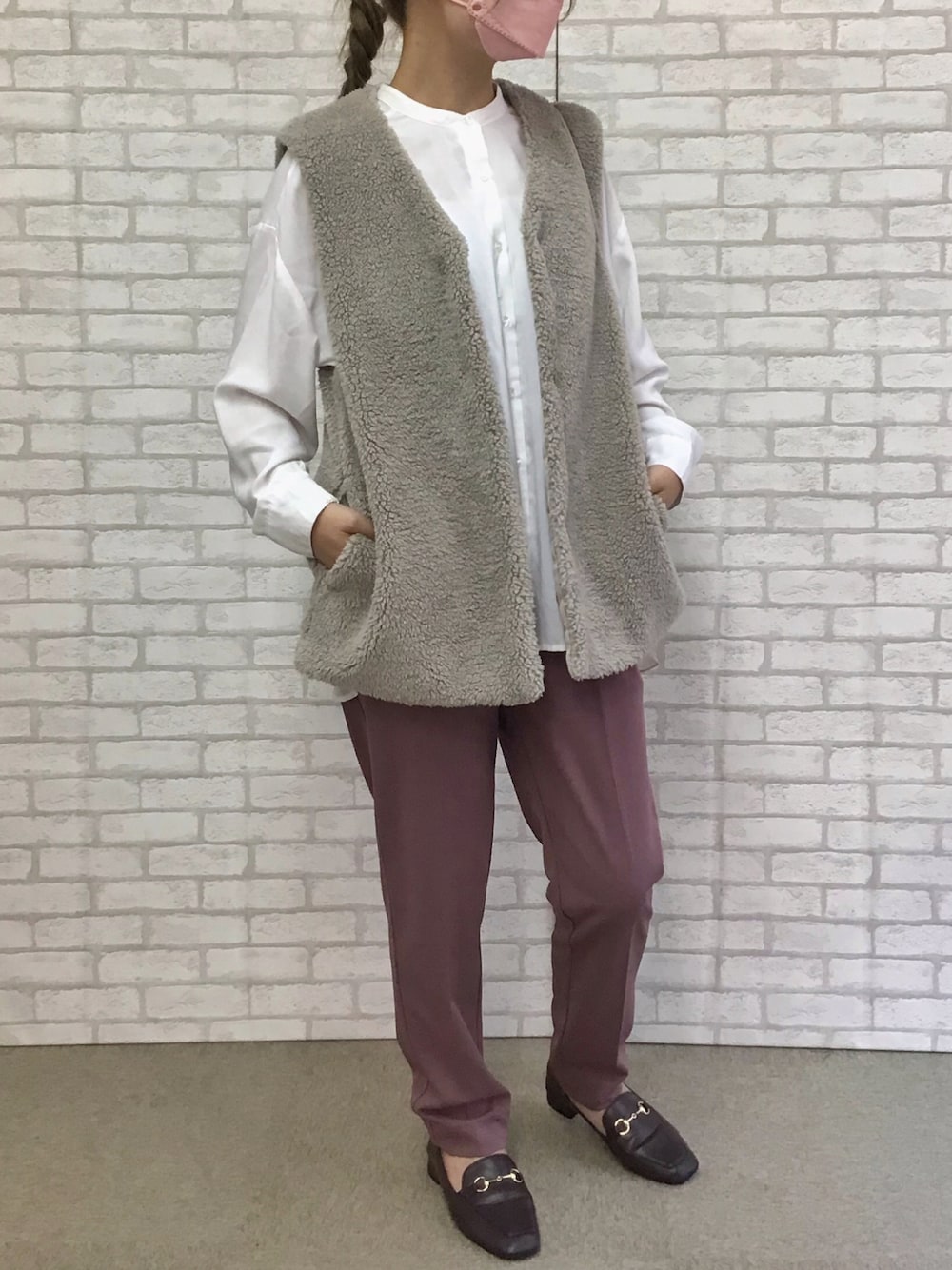 ベージュ系のベストを着用したレディースの秋コーディネートの1枚目の写真