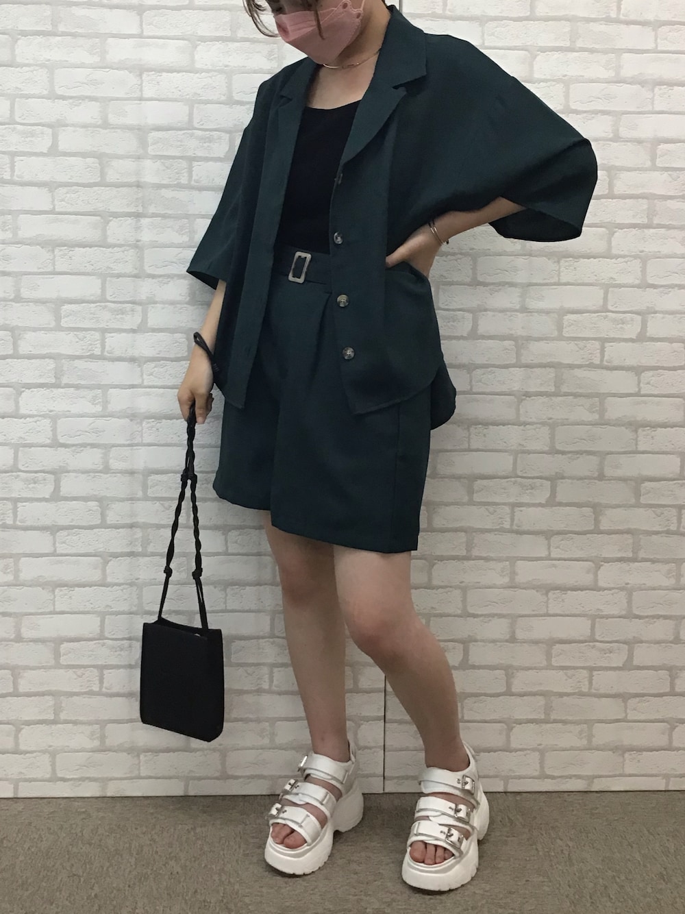 グリーン系のセットアップ、ブラック系のタンクトップ、ホワイト系のサンダルを着用したレディースの夏コーディネートの1枚目の写真