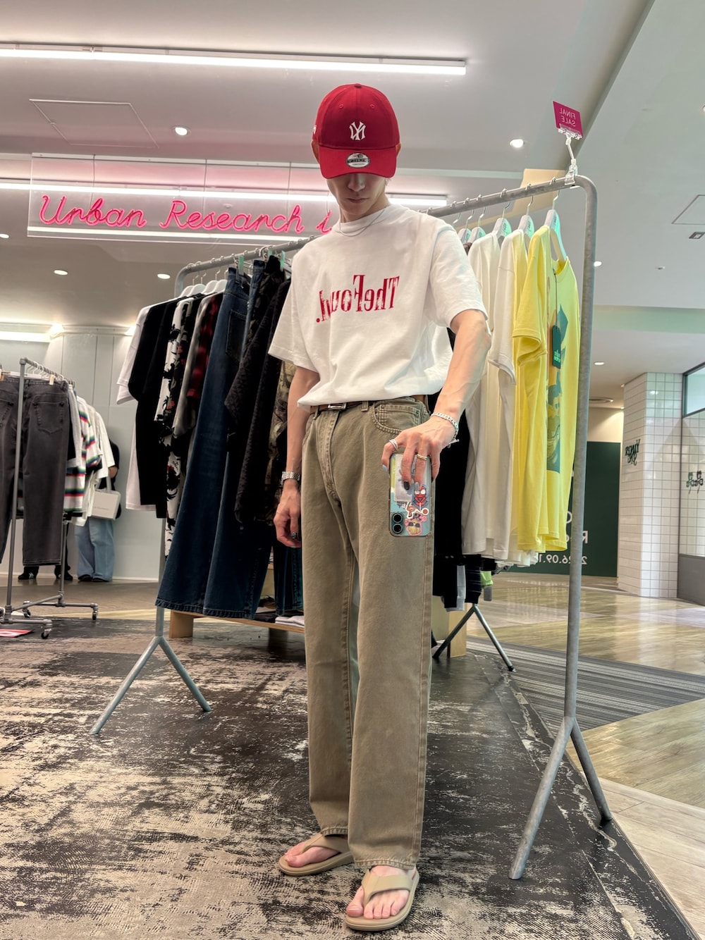 ベージュ系のデニムパンツ、ベージュ系のサンダル、ホワイト系のTシャツ/カットソーを着用したメンズの夏コーディネートの1枚目の写真
