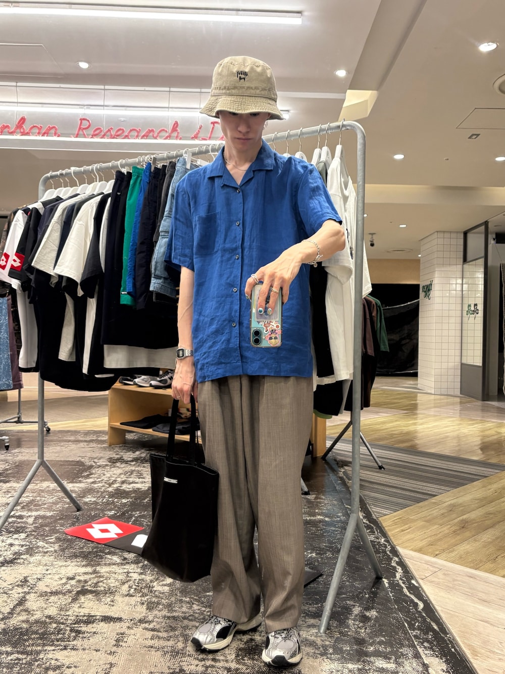 ブルー系のシャツ/ブラウス、ブラック系のトートバッグ、ブラウン系のその他パンツを着用したメンズの夏コーディネートの1枚目の写真