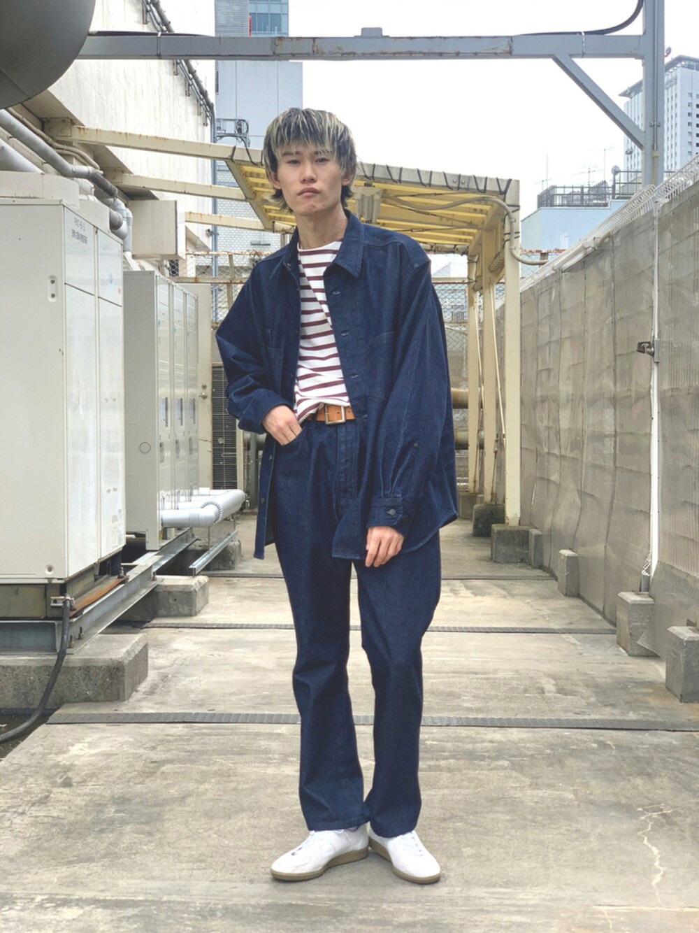 ブルー系のデニムパンツ、ホワイト系のスニーカー、レッド系のTシャツ/カットソーを着用したメンズの秋コーディネートの1枚目の写真