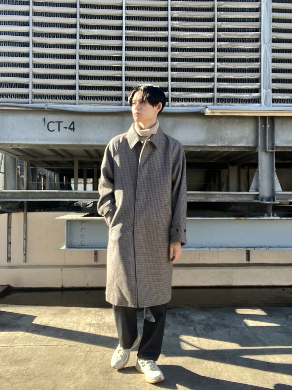 ブルー系のデニムパンツ、ベージュ系のステンカラーコート、ベージュ系のニット/セーターを着用したメンズの冬コーディネートの1枚目の写真