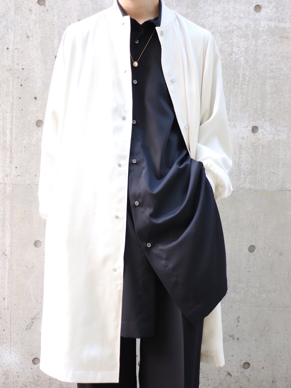 ホワイト系のブルゾン、ブラック系のシャツ/ブラウス、ブラック系のスラックスを着用したメンズの冬コーディネートの2枚目の写真