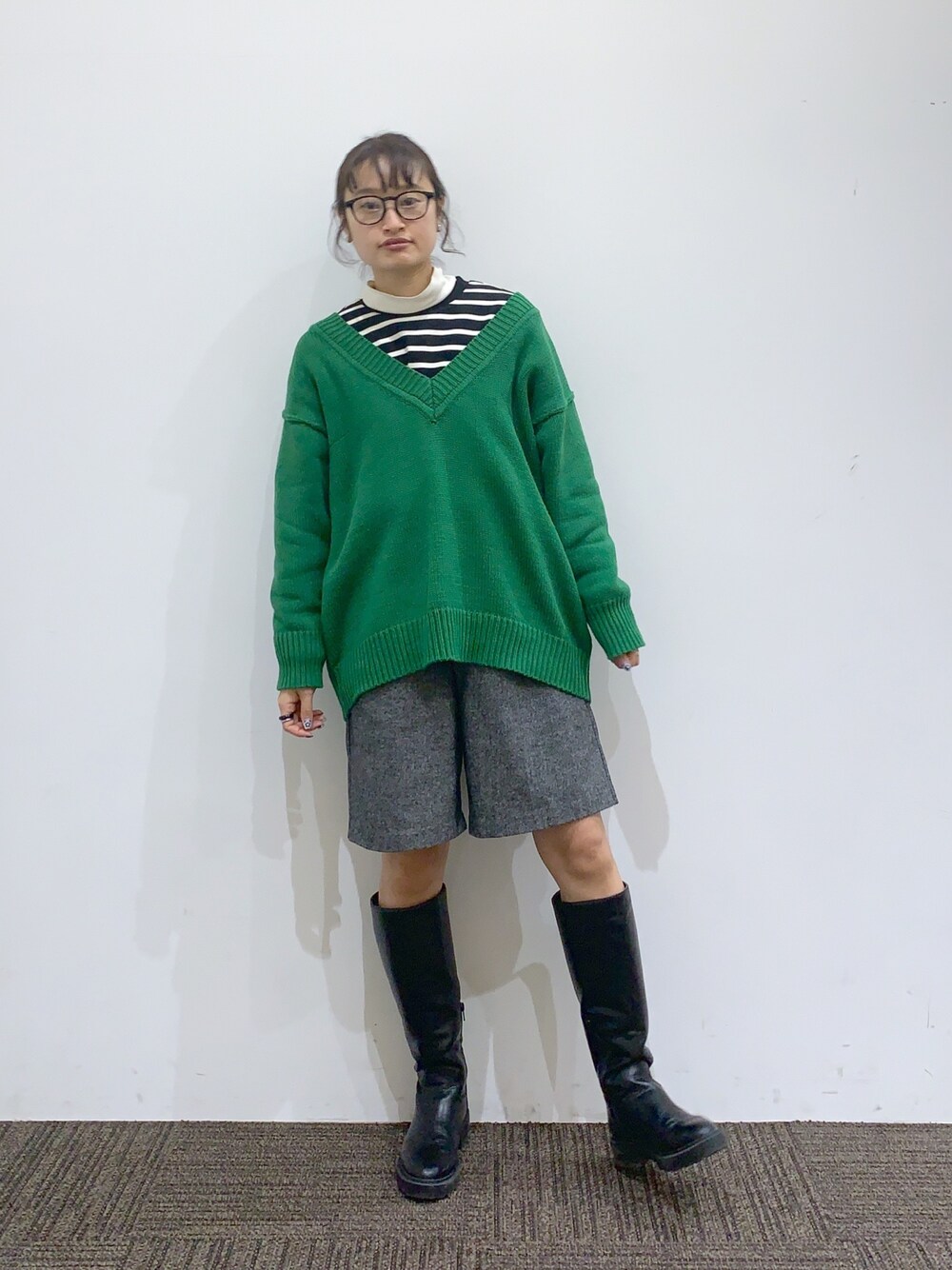 ブラック系のブーツ、グレー系のパンツ、グリーン系のニット/セーターを着用したレディースの冬コーディネートの2枚目の写真