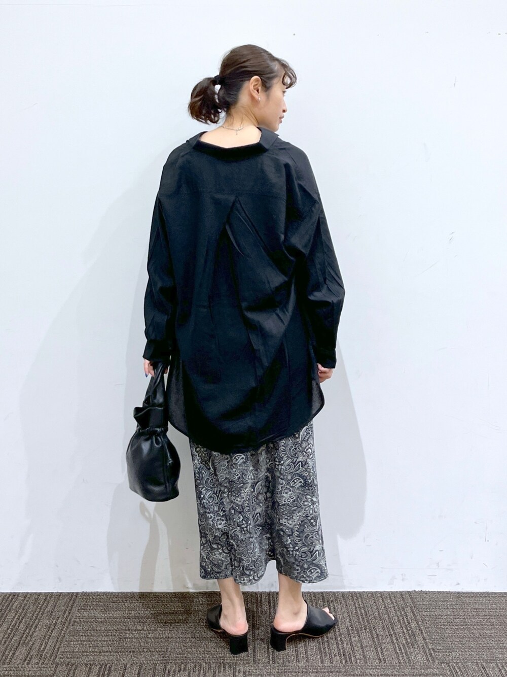 ブラック系のスカート、ブラック系のショルダーバッグ、ブラック系のシャツ/ブラウスを着用したレディースの春コーディネートの4枚目の写真