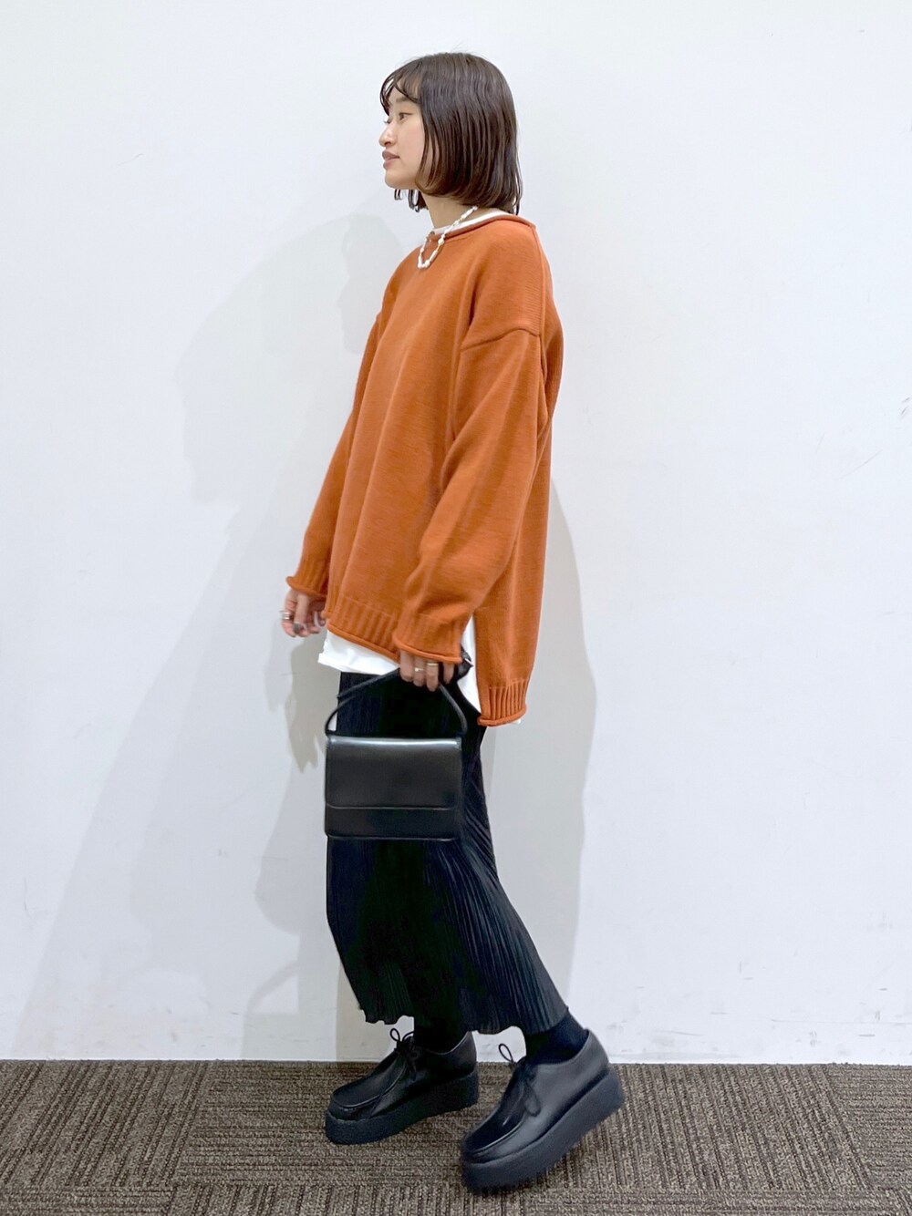 ブラック系のその他シューズ、ブラック系のスカート、ブラック系のショルダーバッグを着用したレディースの冬コーディネートの3枚目の写真