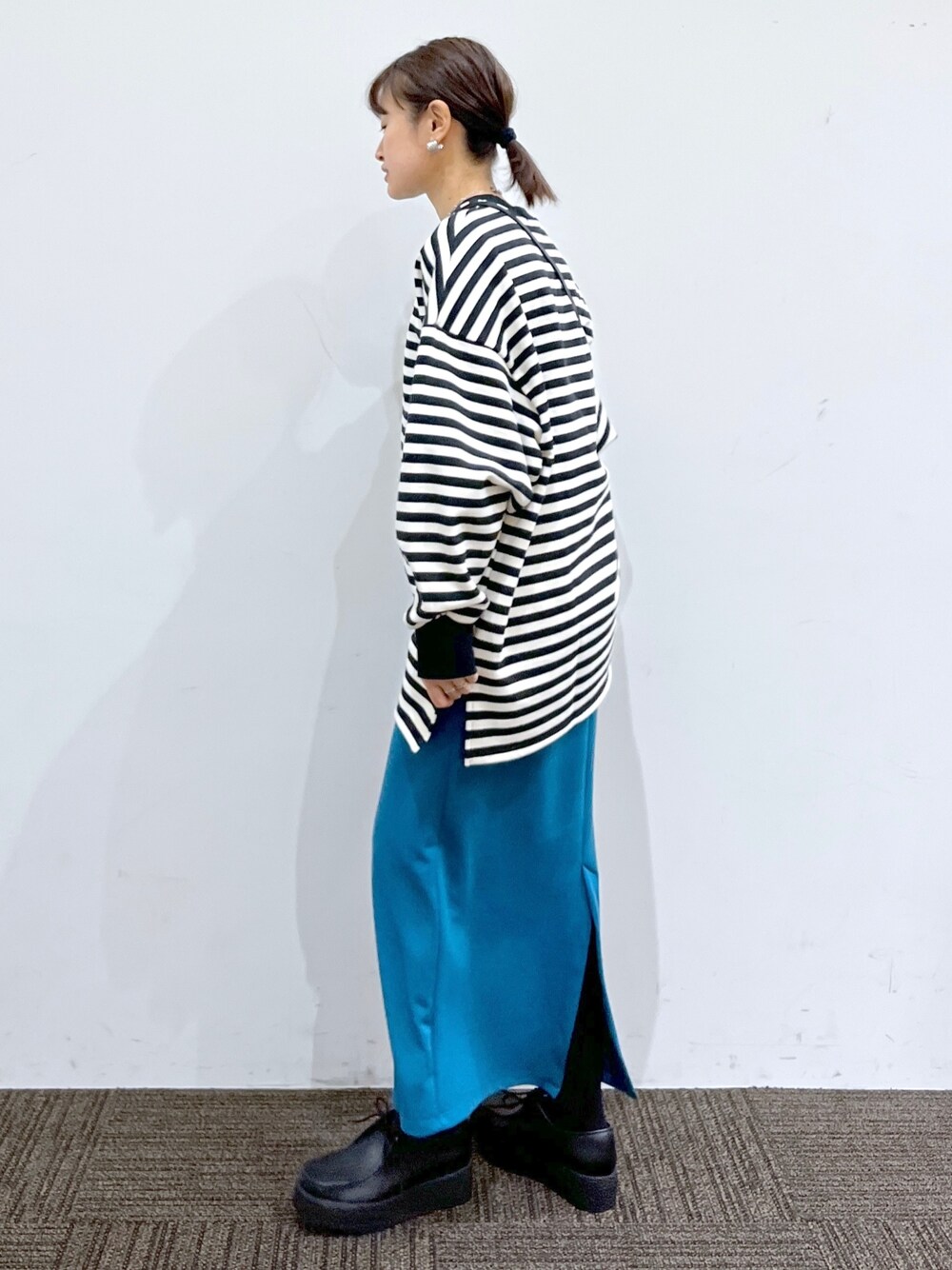 ブルー系のスカート、ブラック系のスウェット、ブラック系のその他シューズを着用したレディースの冬コーディネートの2枚目の写真