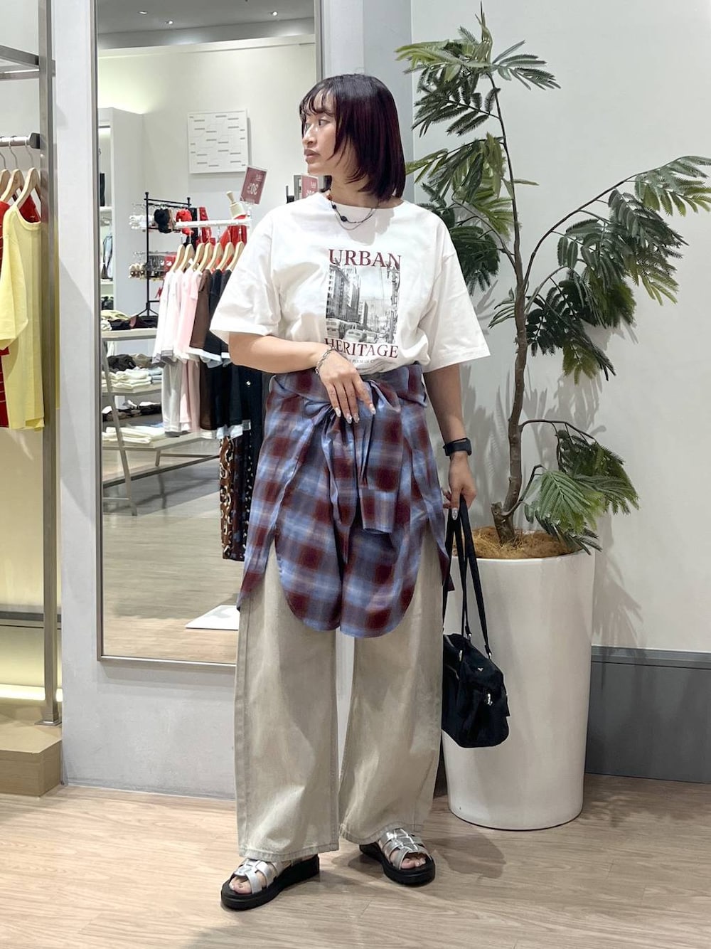 ベージュ系のデニムパンツ、シルバー系のサンダル、ブラック系のボストンバッグを着用したレディースの夏コーディネートの1枚目の写真