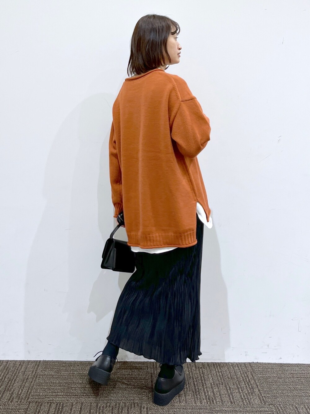 ブラック系のその他シューズ、ブラック系のスカート、ブラック系のショルダーバッグを着用したレディースの冬コーディネートの4枚目の写真