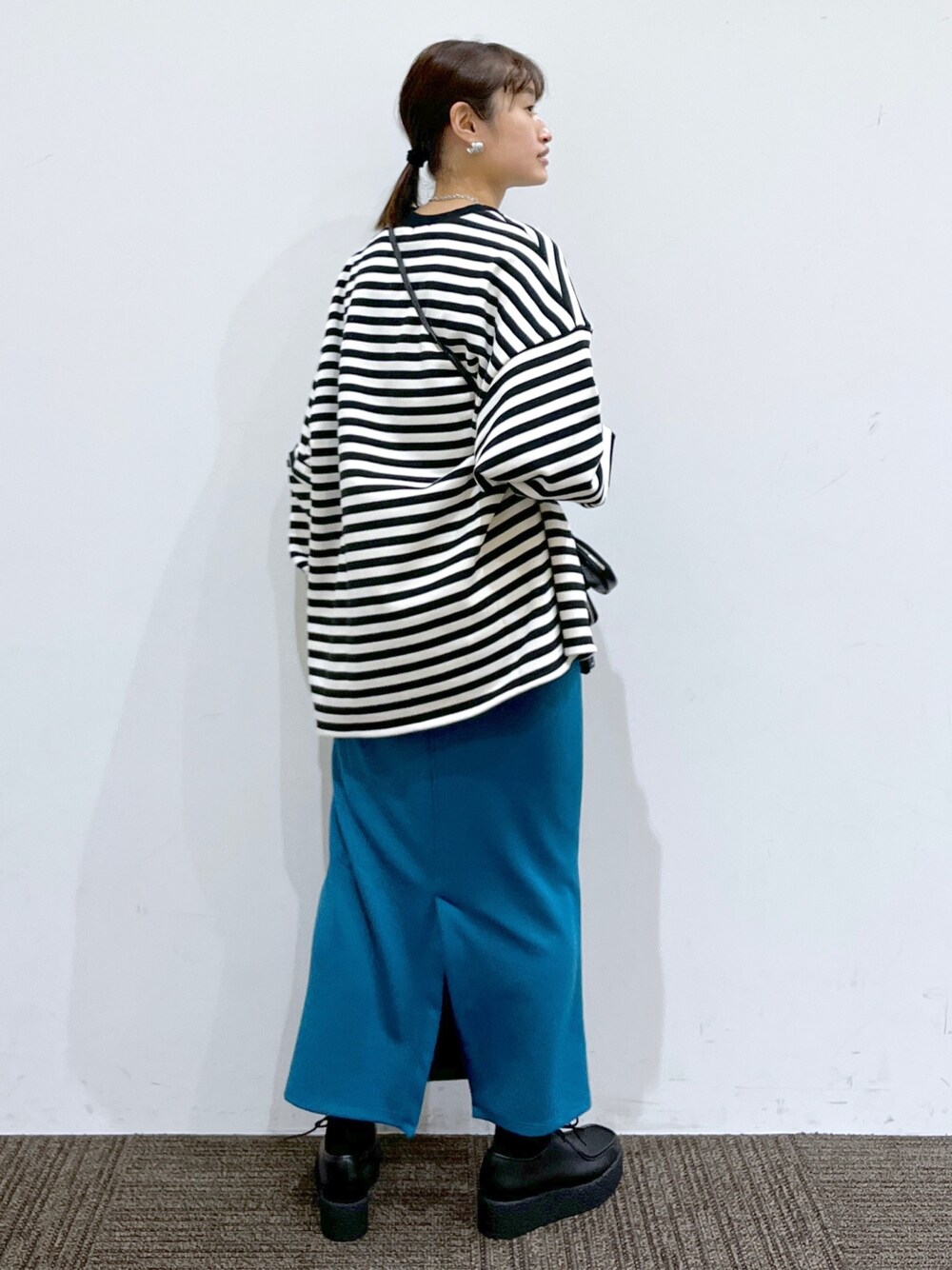 ブルー系のスカート、ブラック系のスウェット、ブラック系のその他シューズを着用したレディースの冬コーディネートの3枚目の写真