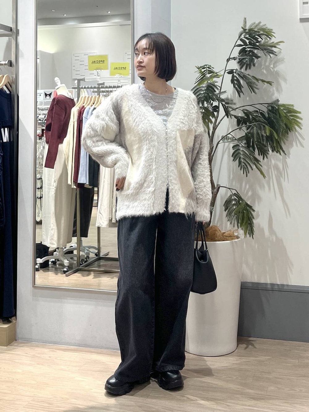 ブラック系のブーツ、ホワイト系のカーディガン/ボレロ、ホワイト系のTシャツ/カットソーを着用したレディースの秋コーディネートの1枚目の写真