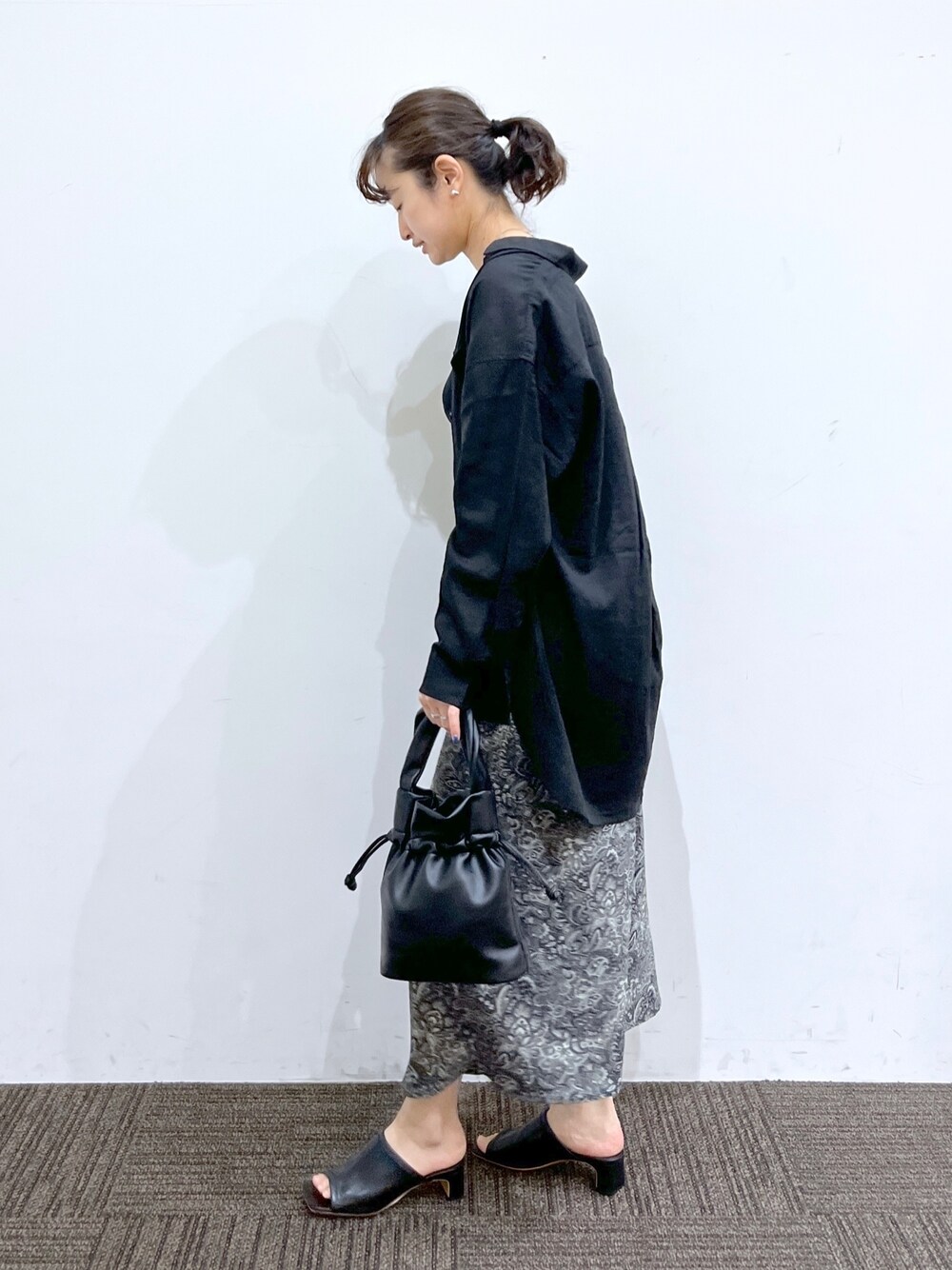 ブラック系のスカート、ブラック系のショルダーバッグ、ブラック系のシャツ/ブラウスを着用したレディースの春コーディネートの3枚目の写真