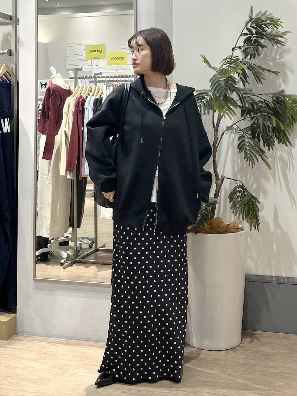 ブラック系のスカート、ブラック系のパーカー、ホワイト系のTシャツ/カットソーを着用したレディースの秋コーディネートの1枚目の写真