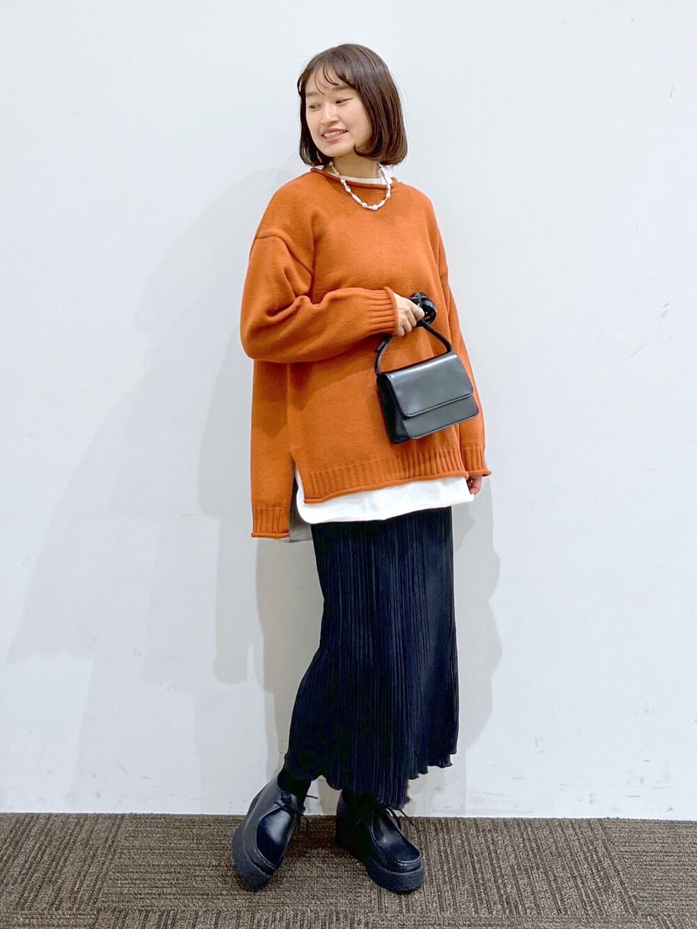 ブラック系のその他シューズ、ブラック系のスカート、ブラック系のショルダーバッグを着用したレディースの冬コーディネートの2枚目の写真