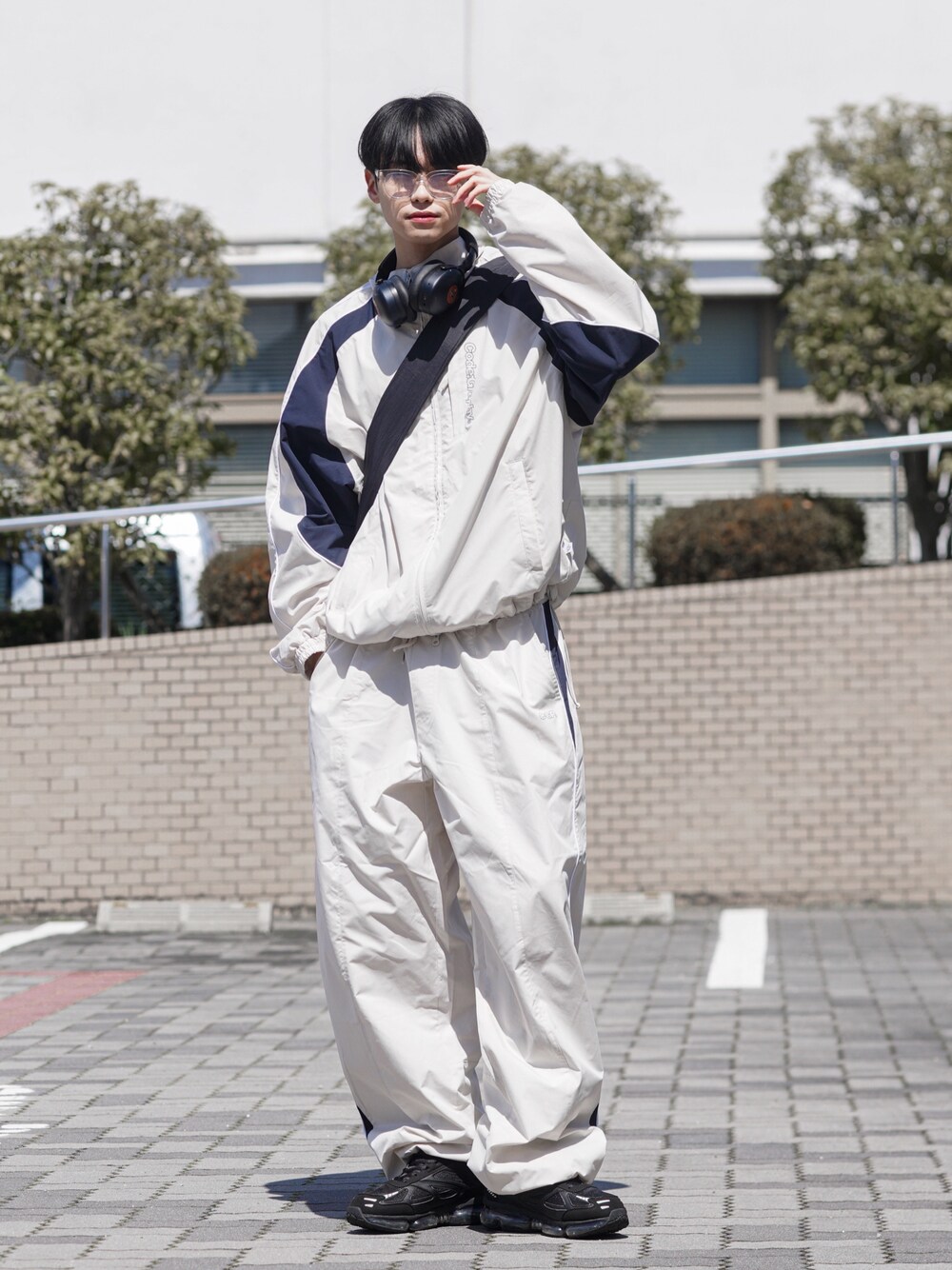 ホワイト系のTシャツ/カットソー、ベージュ系のナイロンジャケット、ベージュ系のその他パンツを着用したメンズの春コーディネートの1枚目の写真