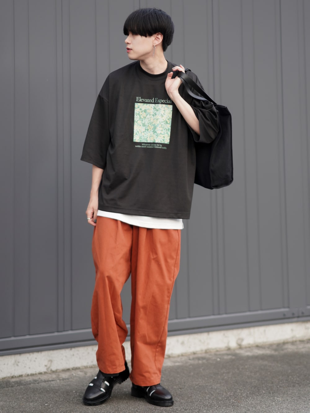 ブラック系のTシャツ/カットソー、ホワイト系のタンクトップ、オレンジ系のチノパンツを着用したメンズの夏コーディネートの1枚目の写真