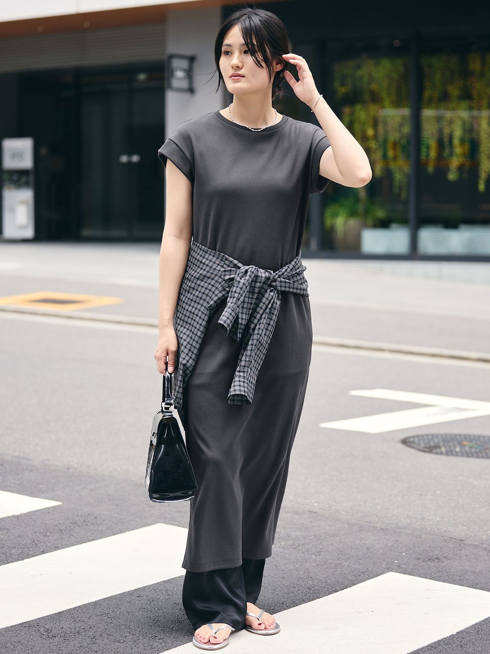 グレー系のワンピース、ブラック系のシャツ/ブラウス、シルバー系のサンダルを着用したレディースの夏コーディネートの1枚目の写真