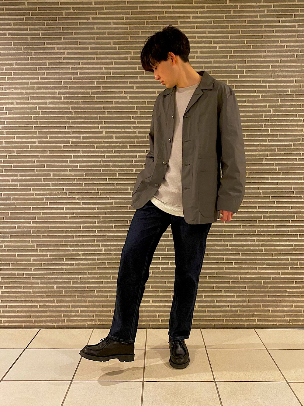 グリーン系のジャケット/アウター、グレー系のニット/セーター、ホワイト系のタンクトップを着用したメンズの春コーディネートの1枚目の写真