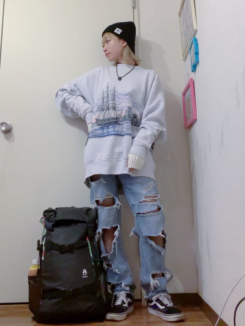 グレー系のスウェット、ブルー系のデニムパンツ、ブラック系のスニーカーを着用したレディースの秋コーディネートの1枚目の写真