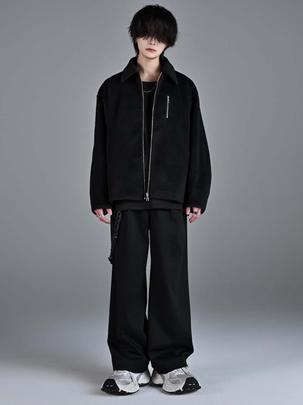 ブラック系のタンクトップ、ブラック系のスラックス、ホワイト系のスニーカーを着用したメンズの秋コーディネートの1枚目の写真