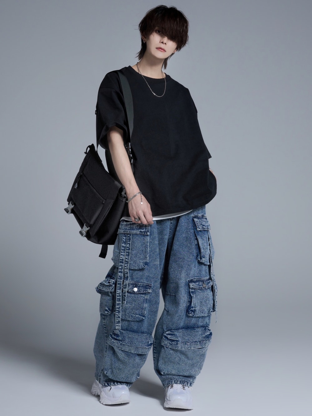 ブルー系のカーゴパンツ、ホワイト系のスニーカー、ブラック系のTシャツ/カットソーを着用したメンズの春コーディネートの1枚目の写真