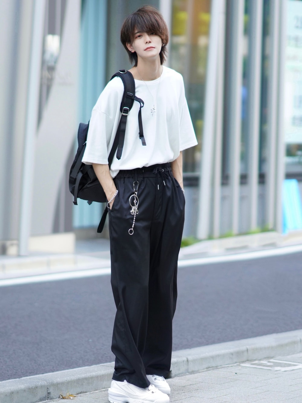 ホワイト系のTシャツ/カットソー、ブラック系のバックパック/リュック、ブラック系のスラックスを着用したメンズの夏コーディネートの1枚目の写真