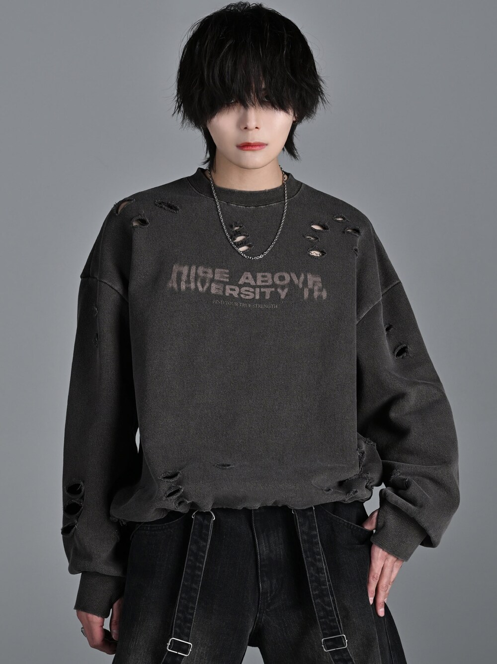 ブラウン系のスウェット、ブラック系のデニムパンツ、シルバー系のネックレスを着用したメンズの冬コーディネートの1枚目の写真