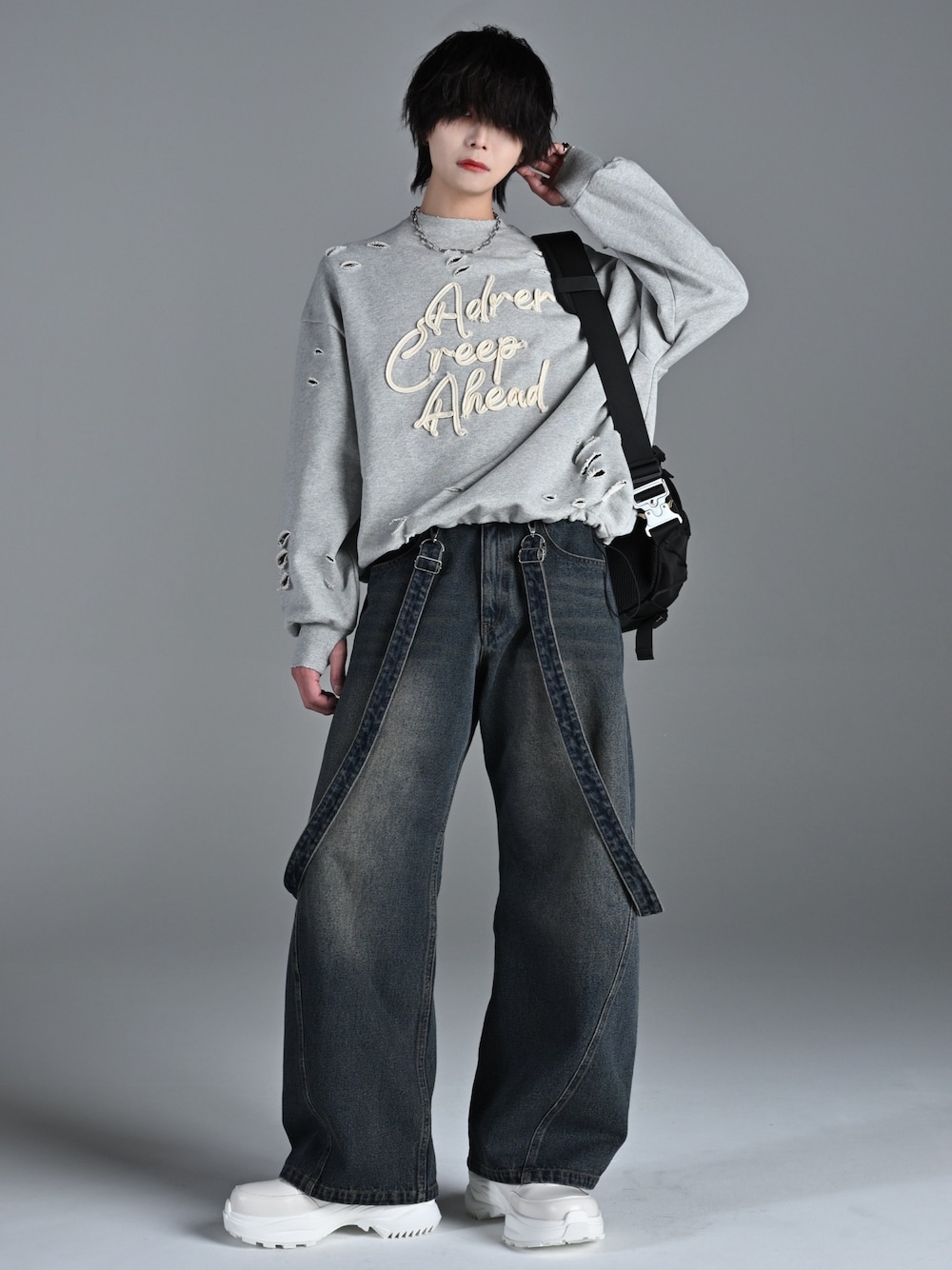 ホワイト系のスニーカー、グレー系のスウェット、ブルー系のデニムパンツを着用したメンズの冬コーディネートの1枚目の写真