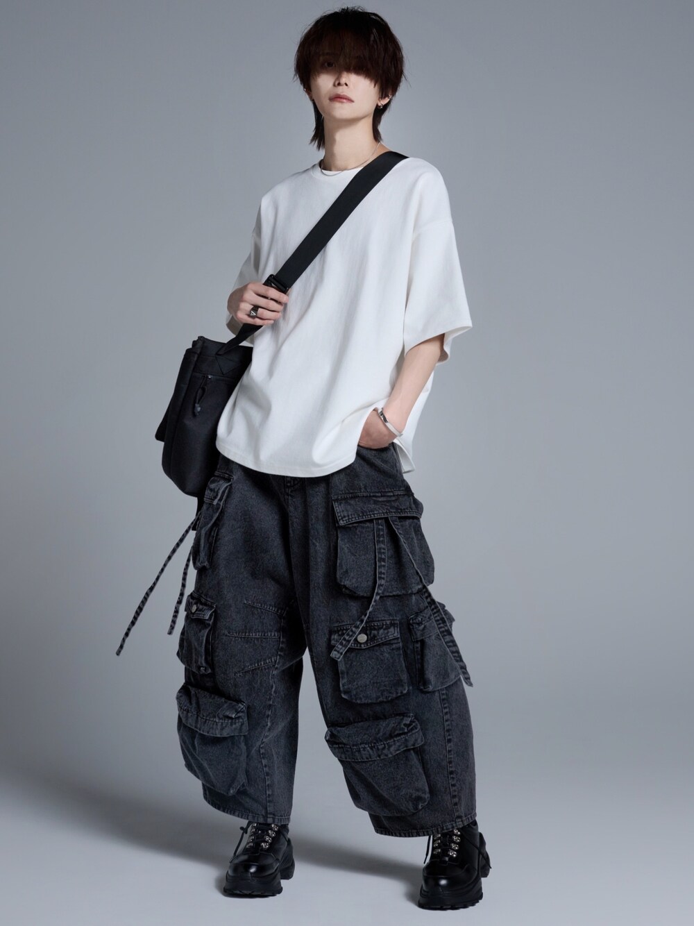 ブラック系のカーゴパンツ、ブラック系のスニーカー、ホワイト系のTシャツ/カットソーを着用したメンズの春コーディネートの1枚目の写真