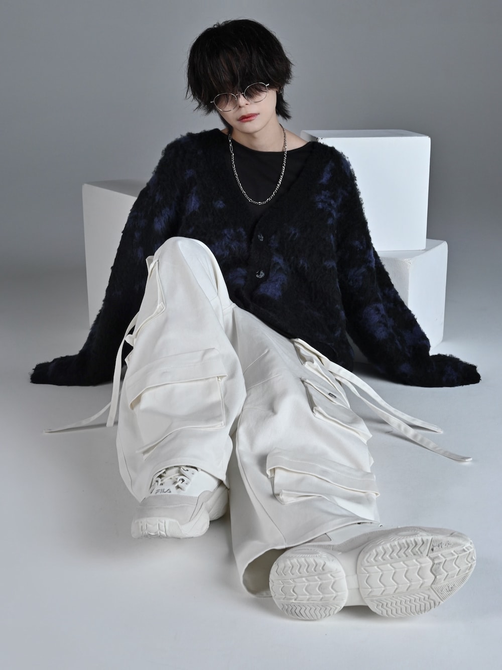 ブラック系のタンクトップ、ホワイト系のスニーカー、ブルー系のカーディガン/ボレロを着用したメンズの秋コーディネートの1枚目の写真