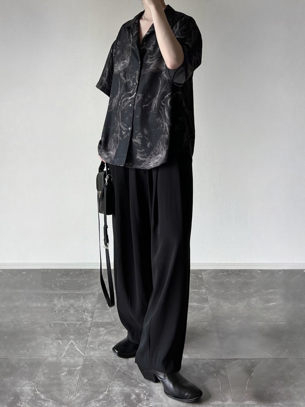 ブラック系のシャツ/ブラウス、ブラック系のスラックス、ブラック系のブーツを着用したメンズの春コーディネートの1枚目の写真