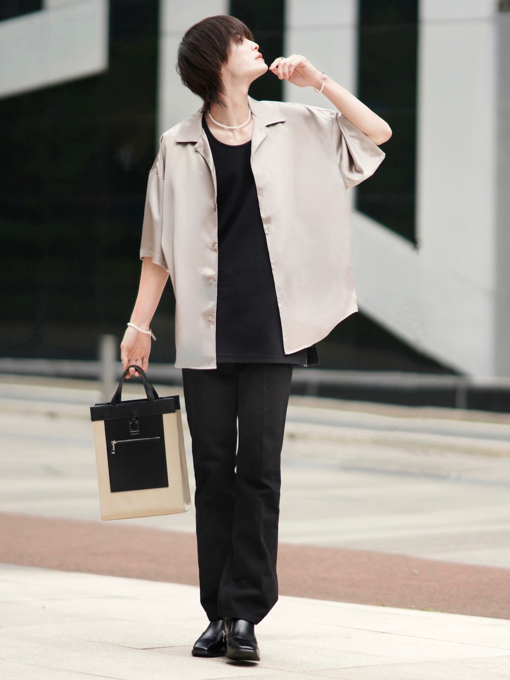 ブラック系のデニムパンツ、ベージュ系のトートバッグ、ブラック系のブーツを着用したメンズの春コーディネートの1枚目の写真