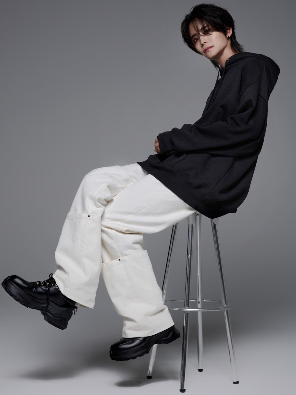 ブラック系のスニーカー、ブラック系のパーカー、ホワイト系のデニムパンツを着用したメンズの夏コーディネートの1枚目の写真