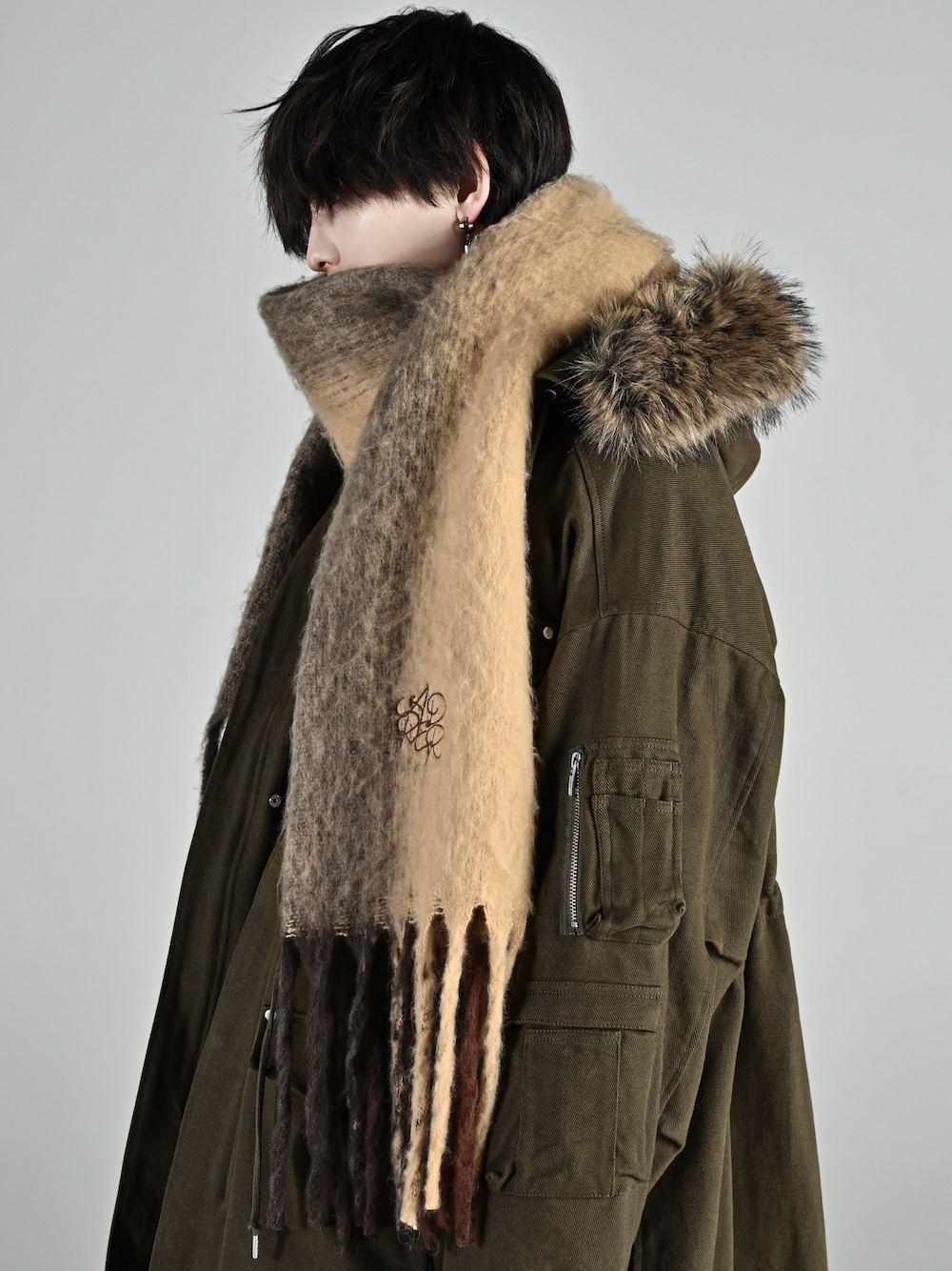 グリーン系のモッズコート、その他のおもちゃ、ブラウン系のマフラーを着用したメンズの秋コーディネートの1枚目の写真