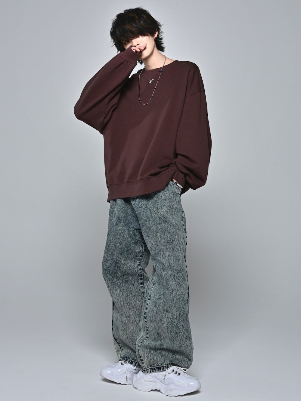 ホワイト系のスニーカー、ブラウン系のスウェット、ベージュ系のデニムパンツを着用したメンズの冬コーディネートの1枚目の写真