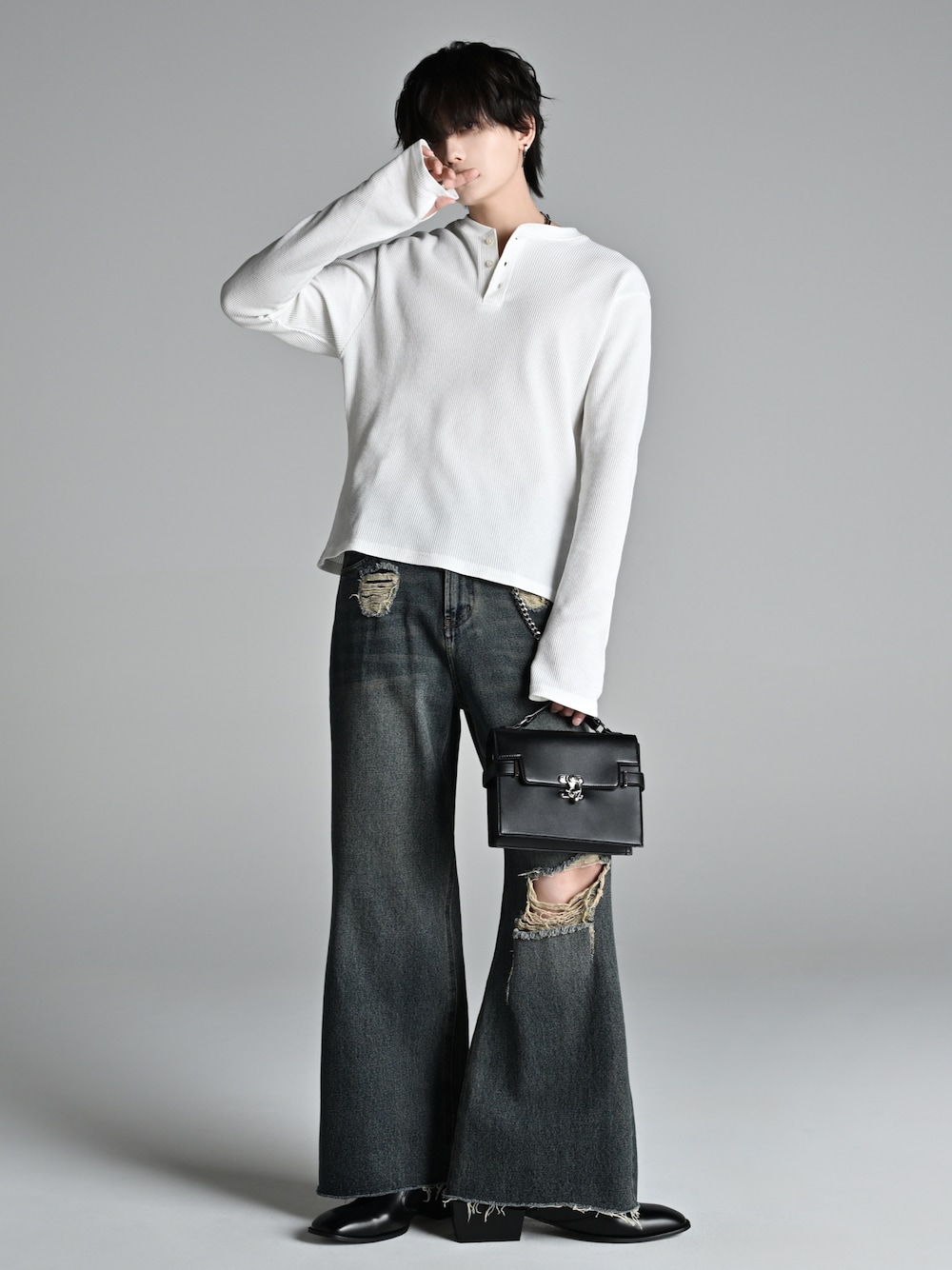 ブルー系のデニムパンツ、ブラック系のショルダーバッグ、ブラック系のブーツを着用したメンズの冬コーディネートの1枚目の写真