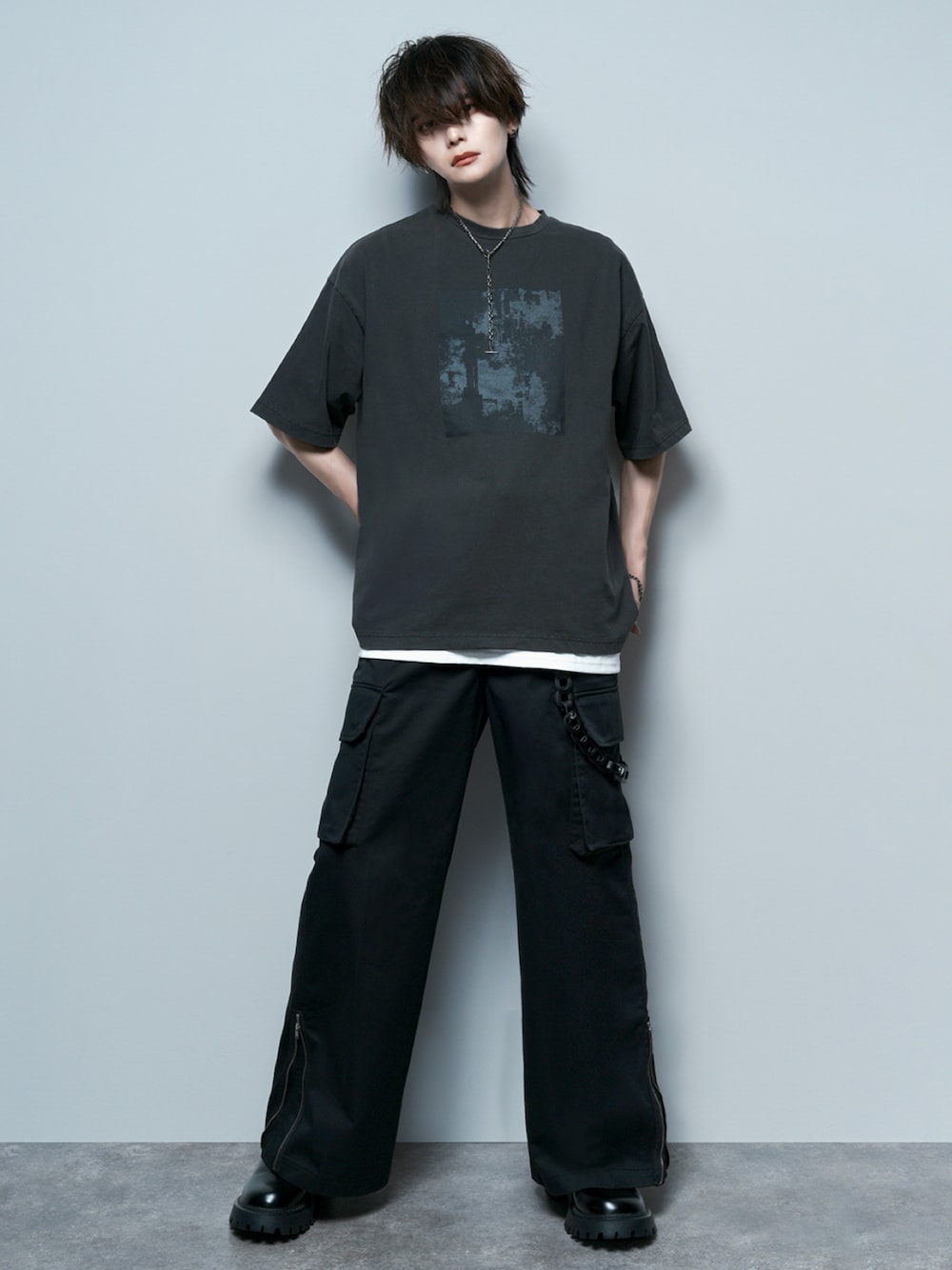 ブラック系のカーゴパンツ、ブラック系のブーツ、ホワイト系のタンクトップを着用したメンズの夏コーディネートの1枚目の写真