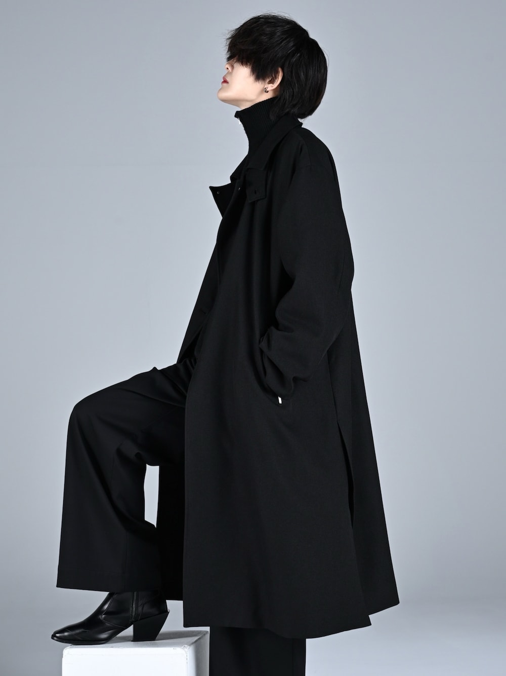 ブラック系のブーツ、ブラック系のニット/セーター、ブラック系のスラックスを着用したメンズの秋コーディネートの1枚目の写真