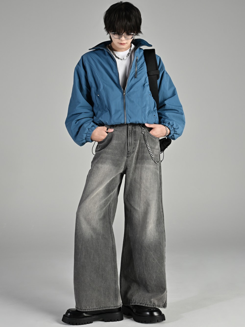 ブラック系のショルダーバッグ、ブルー系のブルゾン、グレー系のデニムパンツを着用したメンズの秋コーディネートの1枚目の写真