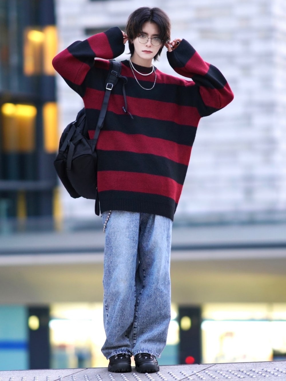 ブルー系のデニムパンツ、ブラック系のスニーカー、ブラック系のバックパック/リュックを着用したメンズの秋コーディネートの1枚目の写真