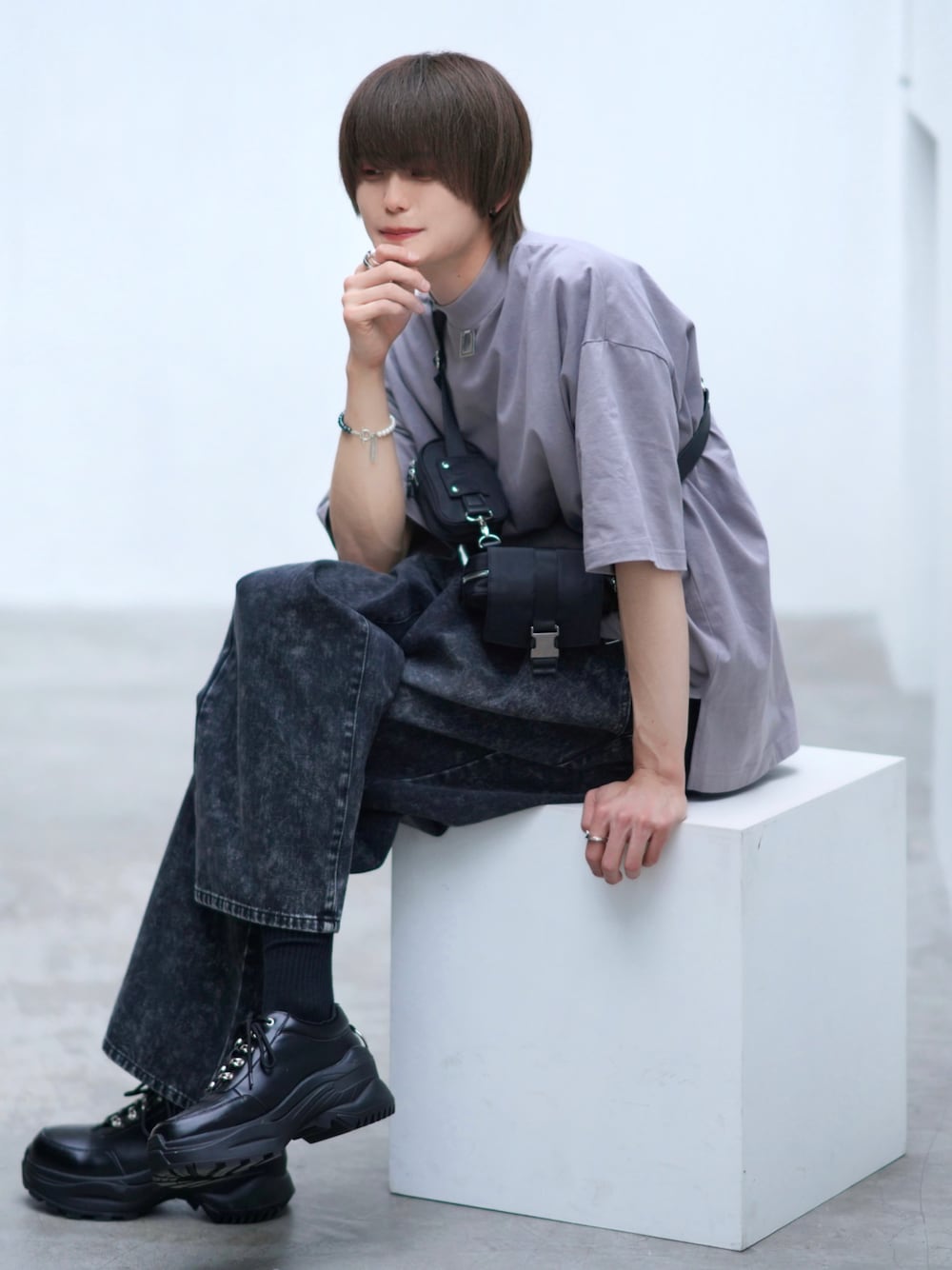 ブラック系のデニムパンツ、ブラック系のスニーカー、ブラック系のショルダーバッグを着用したメンズの春コーディネートの1枚目の写真