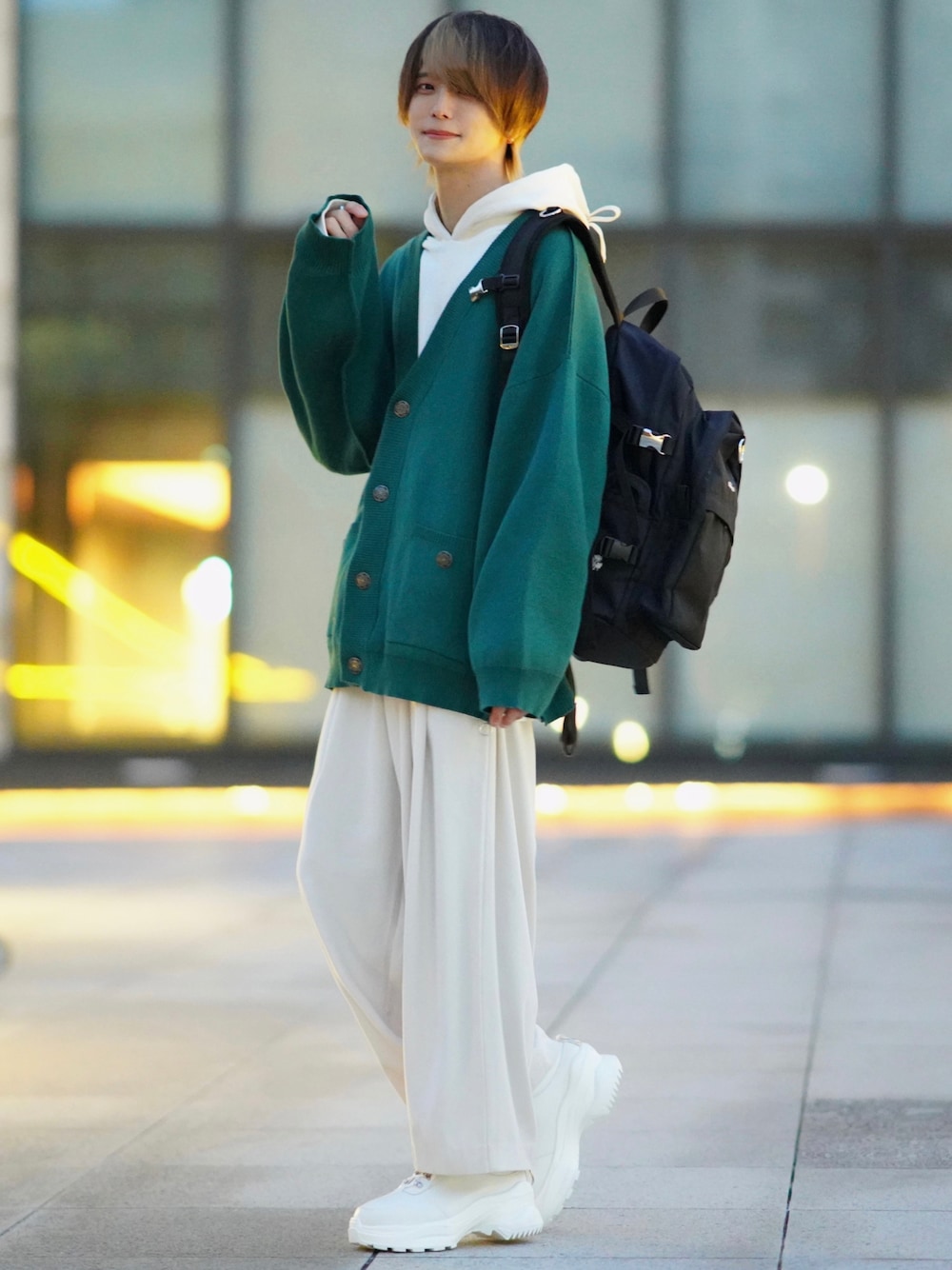 ホワイト系のスラックス、ホワイト系のスニーカー、ブラック系のバックパック/リュックを着用したメンズの冬コーディネートの1枚目の写真