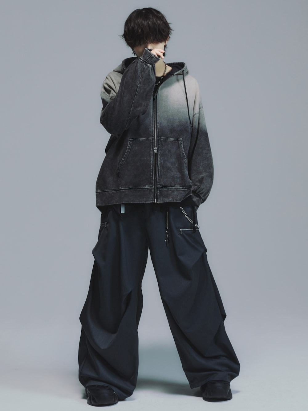 ブラック系のパーカー、レッド系のタンクトップ、ブラック系のスラックスを着用したメンズの秋コーディネートの1枚目の写真